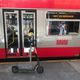A Spin scooter, propped up next to an out-of-service San Francisco bus.